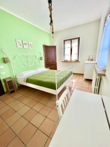 a green bedroom with a bed and a table at Podere al Fico B&B in Collemezzano