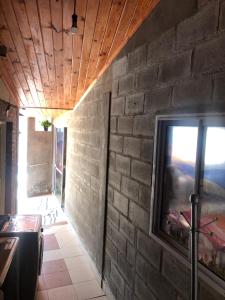 a hallway with a brick wall and a window at ROMA in Reyes