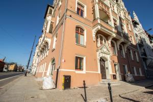 un gran edificio naranja en una calle de la ciudad en Nicolaus Apartment, en Toruń