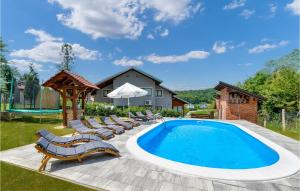 a swimming pool with lounge chairs and an umbrella at Lovely Home In Jastrebarsko With Sauna in Jastrebarsko