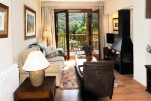 a living room with a couch and a chair at Chardín de Llis-Apartamentos Chardins in Benasque