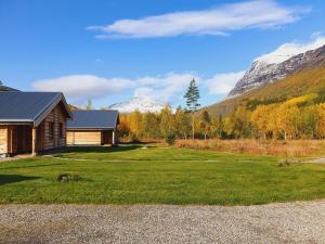 a house with a large yard in front of a mountain at Visit Junkerdal in Junkerdal