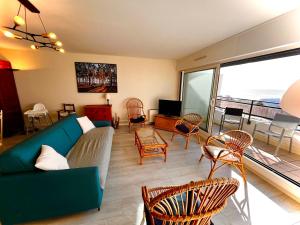 un salon avec un canapé et des chaises dans l'établissement Appt traversant vu Mer et Dunes avec Garage, à Le Touquet-Paris-Plage
