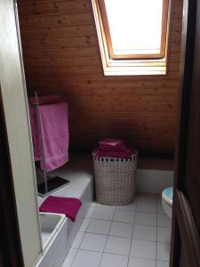 - une petite salle de bains pourvue de toilettes et de serviettes roses dans l'établissement La Baronnie, à Vieux-Pont