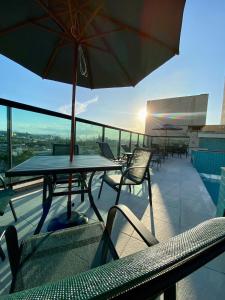 a table and chairs with an umbrella on a roof at Logic Hotel Volta Redonda in Volta Redonda +40 photos