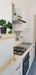 uma cozinha branca com um forno com placa de fogão em Casa vacanze Ale&Va em Alezio