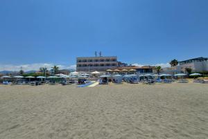 une plage avec des chaises et des parasols et un bâtiment dans l'établissement Hotel Il Gabbiano Beach, à Terme Vigliatore