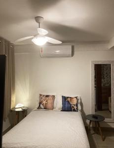 Schlafzimmer mit einem Bett und einem Deckenventilator in der Unterkunft Incrivel loft proximo a praia c pisc em Buzios RJ in Búzios