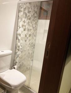 W łazience znajduje się toaleta i przeszklony prysznic. w obiekcie Incrivel loft proximo a praia c pisc em Buzios RJ w mieście Búzios