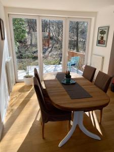 a dining room with a wooden table and chairs at Ház a Pilisben - mókus család a kertben in Pilisszentlászló