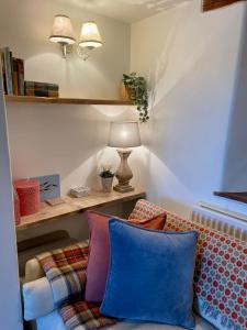 een woonkamer met een bank en een lamp bij HEBE COTTAGE - Idyllic and homely with attention to detail in Atworth