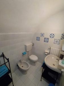 a white bathroom with a toilet and a sink at Alloggio Agrituristico Abruzzomio - Casa Somarello in Goriano Valli