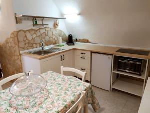 una piccola cucina con un tavolo e un lavandino di Alloggio Agrituristico Abruzzomio - Casa Somarello a Goriano Valli Altre 11 foto