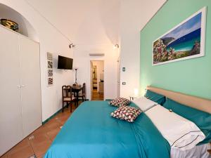 Un dormitorio con una cama azul con almohadas. en Amalfi Andrea's House, en Amalfi