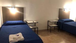 Habitación de hotel con 2 camas y espejo en Posada El Paiman in 