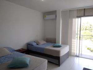 sypialnia z 2 łóżkami i oknem w obiekcie Condominio Terrazas del Sol w mieście Sopetrán