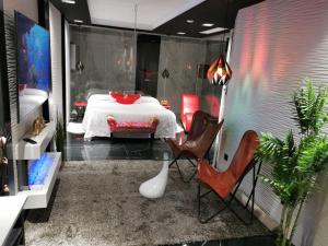 Habitación con cama con sillas y mesa. en Lexury Suite Acqua, en Babilafuente