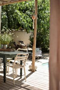 um pátio com uma mesa e cadeiras num deque em Maison d hôtes LA VILLA MADELEINE em Sanary-sur-Mer