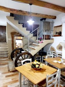 ein Esszimmer mit Holztischen und einer Treppe in der Unterkunft Un Tuffo nel passato "B&B Santu Giuvanni" in Fonni