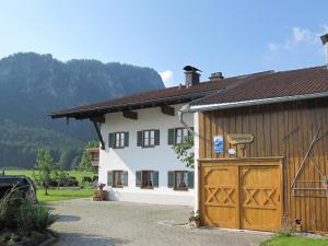 uma grande casa branca com uma garagem de madeira em Hausernhof em Inzell