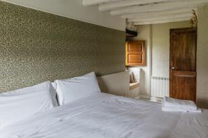 1 dormitorio con cama blanca y pared verde en Nueva Villa Pacheca Casa Rural Boutique, en Santiurde de Toranzo