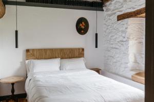 1 dormitorio con 1 cama con reloj en la pared en Nueva Villa Pacheca Casa Rural Boutique, en Santiurde de Toranzo