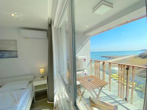 a bedroom with a balcony with a view of the ocean at Paradiso Aparthotel - Private apartment -BSR-2 in Nesebar