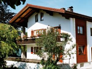 a white house with a tree in front of it at Beim Wirtschmied - Chiemgau Karte in Inzell