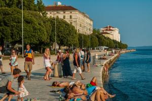 un grupo de personas en una playa cerca del agua en Bristol lux 3BR apartment with view, en Zadar