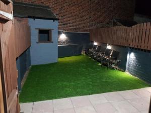 a patio with green grass and chairs in a building at Highfields Living in Sheffield