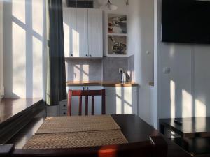 una cocina con armarios blancos, una mesa y una barra en Apartament Teatralny en Gdansk