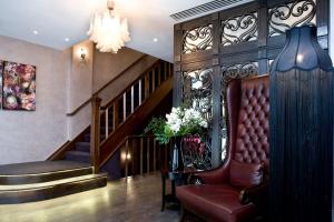 a lobby with a staircase and a chair and flowers at Karma Sanctum Soho Hotel in London