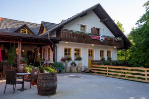 une maison avec un baril devant elle dans l'établissement Gostilna Logar, à Hotemaže