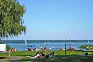 un gruppo di persone sedute sull'erba di una spiaggia di Semi-detached house, Plau am See a Plau am See