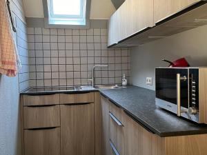 a kitchen with a sink and a microwave at Holiday home in Reimboldshausen with balcony in Kemmerode