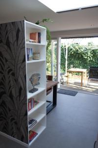 a book shelf in a living room with a desk at Quetzal in Schoorl