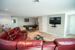 a living room with a leather couch and a pool table at The Retreat at Graceland in Memphis