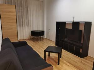 a living room with a couch and a flat screen tv at Rin Grand Hotel in Bucharest