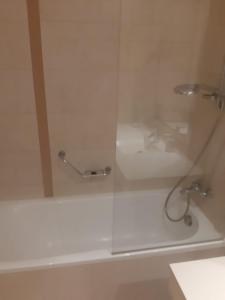 y baño con ducha y puerta de cristal. en Rin Grand Hotel, en Bucarest