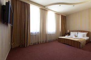 a hotel room with a bed and a flat screen tv at Best Western Bohemian Resort in Sevan