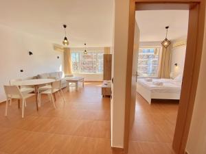 uma sala de estar com uma mesa e uma cama em Panorama Dreams - Private Apartment - BSR em Sveti Vlas