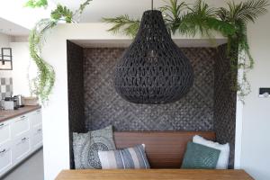 a pendant light hanging from a wall with pillows at Quetzal in Schoorl