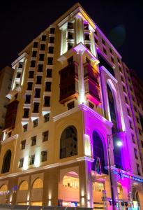Tulip Inn Al Daar Rawafid في المدينة المنورة: مبنى عليه انوار ارجوانيه
