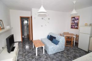 a living room with a couch and a tv and a table at Vv. Apartamento Paco y Nina in Frontera