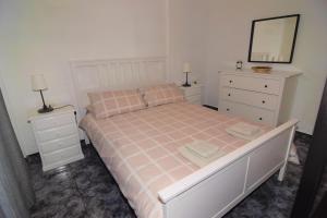 a bedroom with a bed with two dressers and a mirror at Vv. Apartamento Paco y Nina in Frontera
