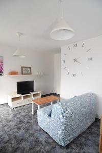 a living room with a couch and a clock on the wall at Vv. Apartamento Paco y Nina in Frontera