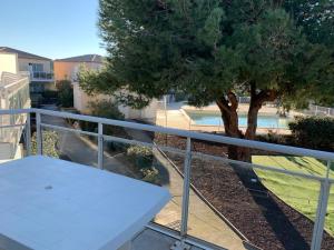 una mesa blanca en un balcón con un árbol en T2 Les jardins Gruissan en Gruissan