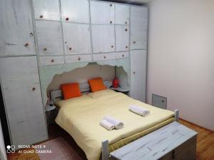 1 dormitorio con 1 cama con armarios blancos y almohadas de color naranja en Room & Apartment Saint John, en Dubrovnik