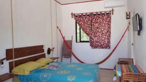 a bedroom with a bed and a window with a curtain at EncantaLuna in Holbox Island