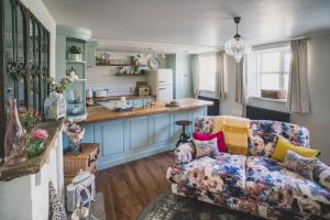 a living room with a couch and a kitchen at The Burrow Escape in Branston